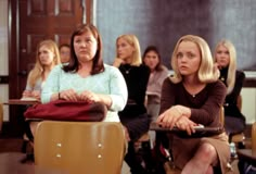 two women sitting in front of a group of other people