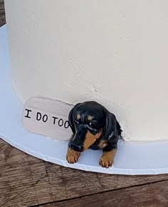 a dog figurine sitting on top of a white cake