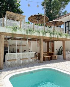 an outdoor kitchen and pool area with umbrellas