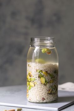 a jar filled with rice and nuts on top of a table