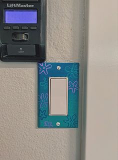 a blue and white light switch sitting on top of a wall