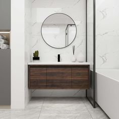 a bathroom with marble walls and flooring, a round mirror on the wall above the sink