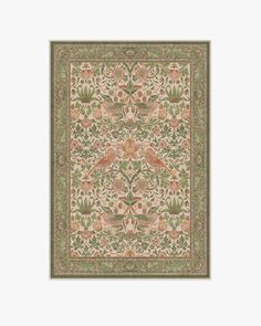 an intricately designed rug with flowers and leaves in green, orange and pink colors