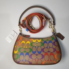 COACH Teri Shoulder Bag In Rainbow Signature Canvas MSRP:  $378 Signature coated canvas and smooth leather Two credit card slots Inside multifunction pocket Zip-top closure, fabric lining Detachable handle with 8 1/4" drop Detachable strap with 22 3/4" drop for shoulder or crossbody wear 9 1/2" (L) x 6" (H) x 3" (W) The Coach Foundation continues to partner with the Hetrick-Martin Institute, Point Foundation and CenterLink Community of LGBTQ Centers to create supportive environments where LGBTQI Coach Multicolor Shoulder Bag For Everyday, Multicolor Coach Top Handle Shoulder Bag, Luxury Multicolor Coach Bag, Coach Bucket Bag, Multicolor Coach Shoulder Bag For On-the-go, Multicolor Coach Bags With Gold-tone Hardware, Vintage Shoulder Bag, Coach Shoulder Bag, Signature Canvas