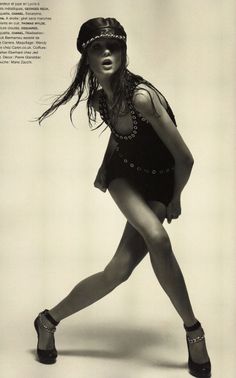 a black and white photo of a woman in high heels, with her hair blowing in the wind