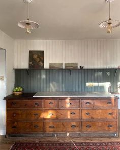 an old wooden dresser sitting in the corner of a room with two lights on it