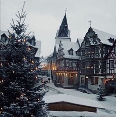 a christmas tree in front of a building with lights on it