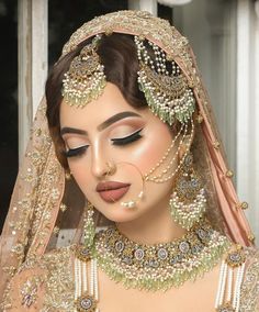 a woman in a bridal outfit with jewelry on her face