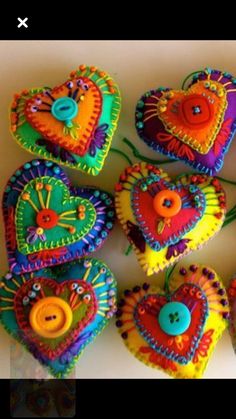 several colorful heart shaped ornaments with buttons on them