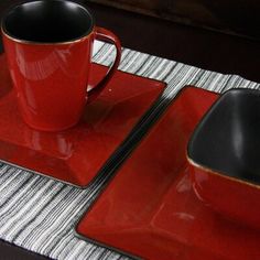 red and black placemats with two cups on them