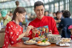 a man and woman sitting at a table eating food