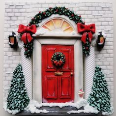 a red door decorated with christmas wreaths and bows is shown in front of a white brick wall