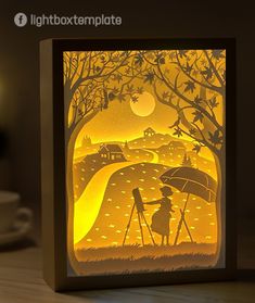 a paper cut card with an image of two people under an umbrella in the rain