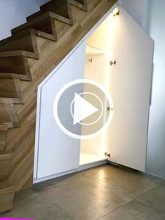 a white cabinet under a staircase next to a wooden handrail and stairs in a room