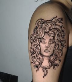 a woman's arm with a snake tattoo on it and her face in the center