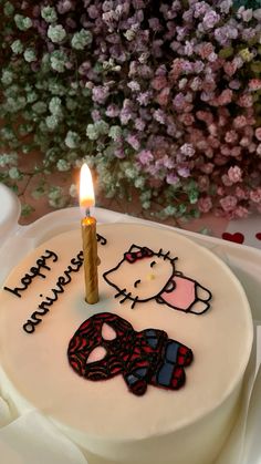 a hello kitty birthday cake with a candle