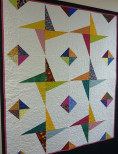 a colorful quilt hanging on the wall