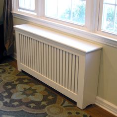 a white radiator sitting next to a window in a room with hardwood floors