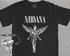 ALL ORDERS NEEDED FOR CHRISTMAS DELIVERY MUST BE PLACED BY DECEMBER 16TH!!  FREE STICKER WITH YOUR PURCHASE! Nirvana Unisex Comfort Colors® Vintage Band Tee | In Utero Nirvana Tour | 90s Shirt | Kurt Cobain | Oversized Music Rock | Festival Clothes Take a trip back to the 1990s with this awesome vintage Nirvana tee! This shirt features the iconic Nirvana smiley face logo printed on a black short sleeve t-shirt in a soft and lightweight cotton blend. The Nirvana logo on the front has cracking and Logo Nirvana, Nirvana T Shirts, Nirvana Merch, Nirvana Logo, Nirvana Smiley Face, Nirvana Tee, Nirvana Band, Vintage Band T Shirts, In Utero