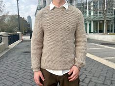 a man standing in the street wearing a sweater