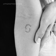 a small sun and moon tattoo on the arm