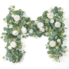 white flowers and greenery are arranged in the shape of letter n