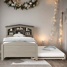 a bedroom with a bed, night stand and christmas wreath on the wall above it