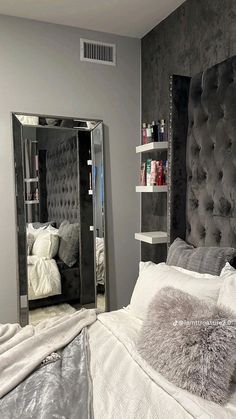 a bedroom with a large mirror on the wall and a bed in front of it