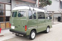 a green van parked in front of a building