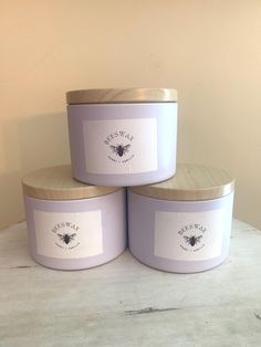 three lavender candles sitting on top of a table