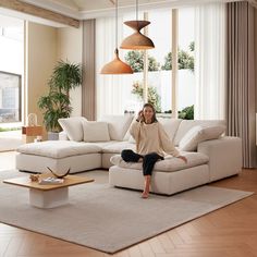 a woman sitting on top of a white couch in a living room