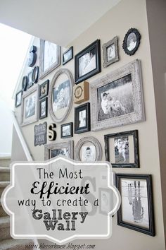 a wall with many frames and pictures on the wall next to stairs in a home