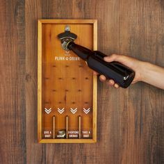 a person holding a bottle opener in front of a wooden box