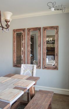 a dining room table and chairs with mirrors on the wall