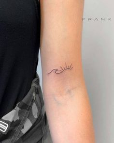 a woman's arm with a small wave tattoo on the left side of her arm