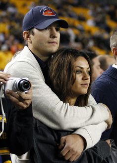 a man and woman hugging each other at a game