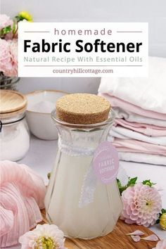 homemade fabric softener with essential oils and flowers in the background on a cutting board