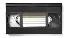 an old black tape recorder with a white label on the side and two cassettes attached to it