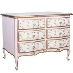 a pink and gold painted chest of drawers