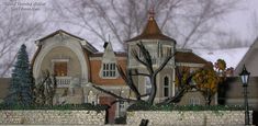 a model of a house on display in front of a brick wall and tree with no leaves