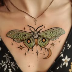 a woman's chest with a green butterfly tattoo on the top of her stomach