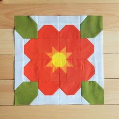 an orange and yellow flower sitting on top of a wooden table