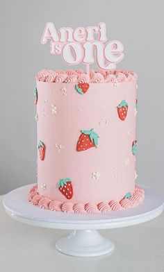 a pink cake with strawberries on it and the words ament is one written on top