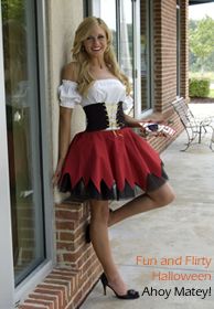 a woman in a red and black costume leaning against a brick wall with her legs crossed