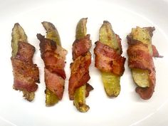 bacon wrapped pickles on a white plate