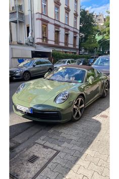 a green sports car is parked on the street