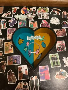 a heart shaped box sitting on top of a table covered in stickers