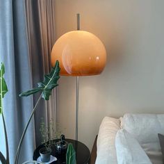 a living room with a white couch and a lamp on the table next to it