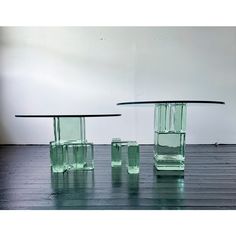 three green glass tables sitting on top of a wooden floor