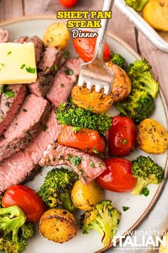 a plate with steak, tomatoes, broccoli and other food items on it